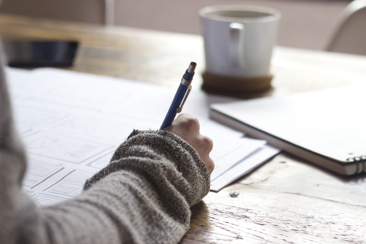 Photo of a hand holding a pen and writing